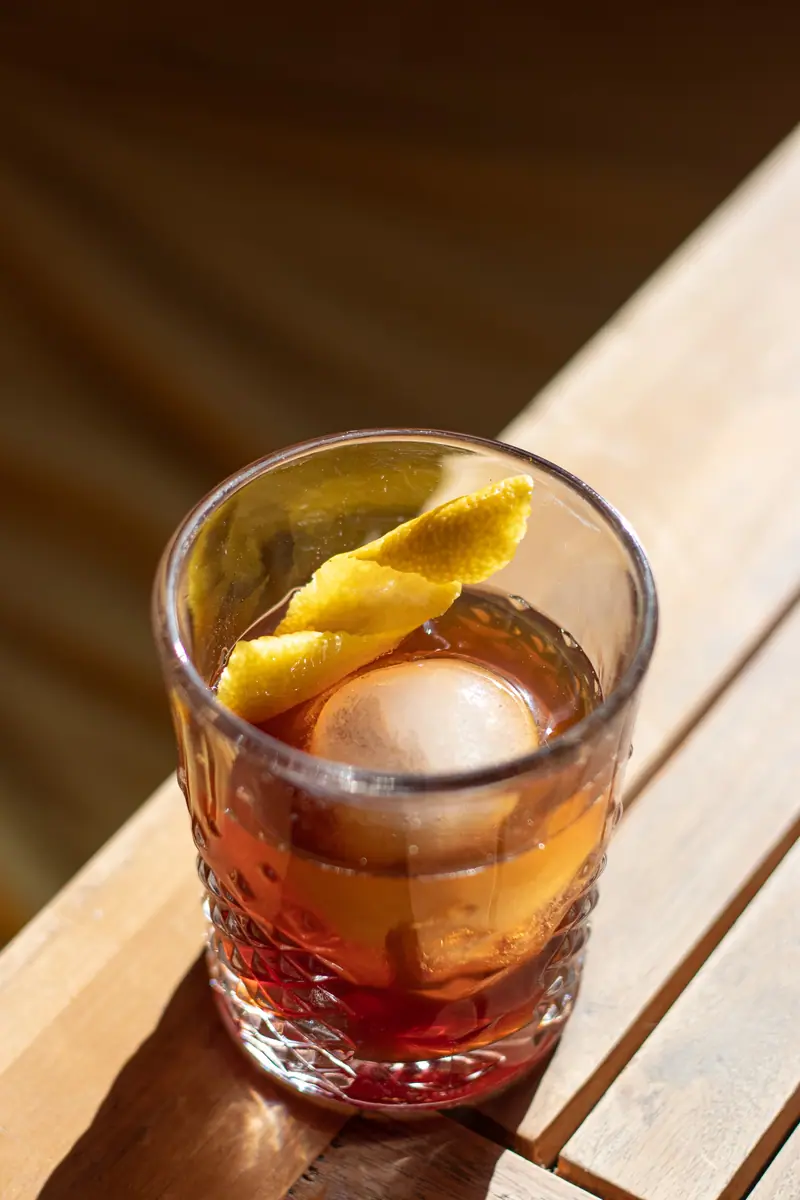 Cocktail mit Orangenzeste und Eiskugel