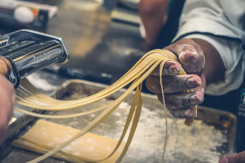 Frische Pasta wird von Hand geschnitten